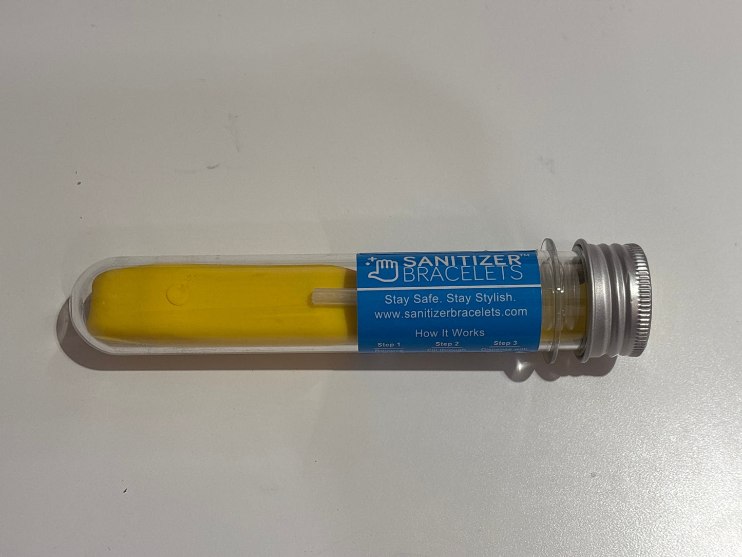 Yellow object in a clear tube with a blue label on a white background
