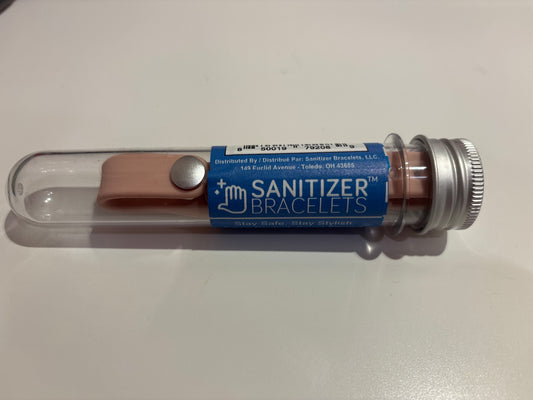 Sanitizer bracelet in a clear container on a white surface